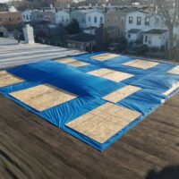 Roof covered in tarp and boards